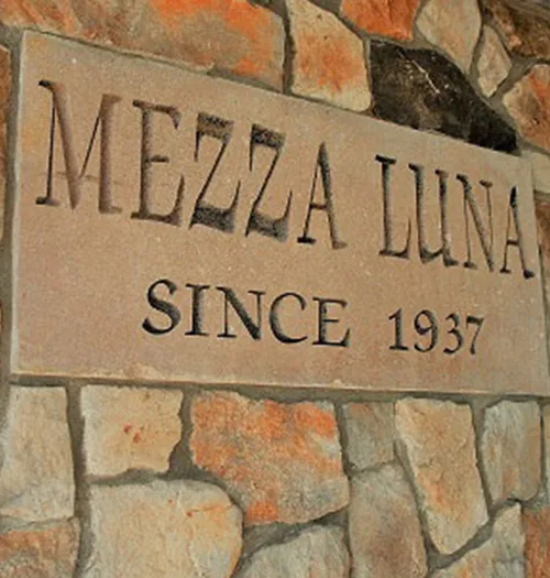 Stone sign reading Mezza Luna Since 1937