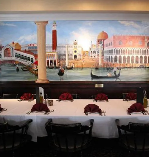 Venetian canal mural above a dining table